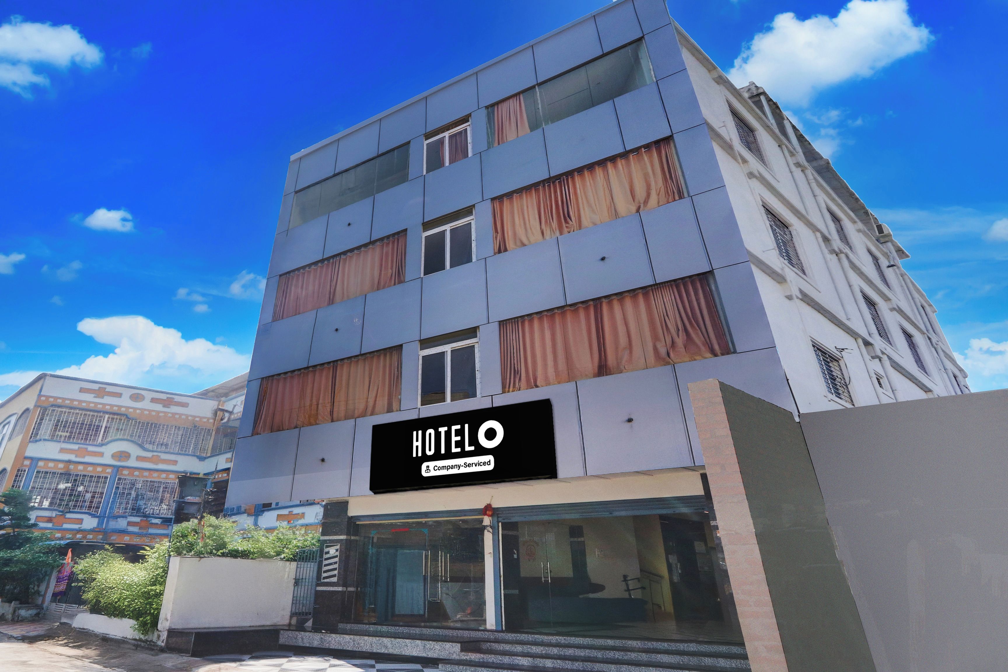 A multi-story hotel with a sign indicating it is company-serviced.