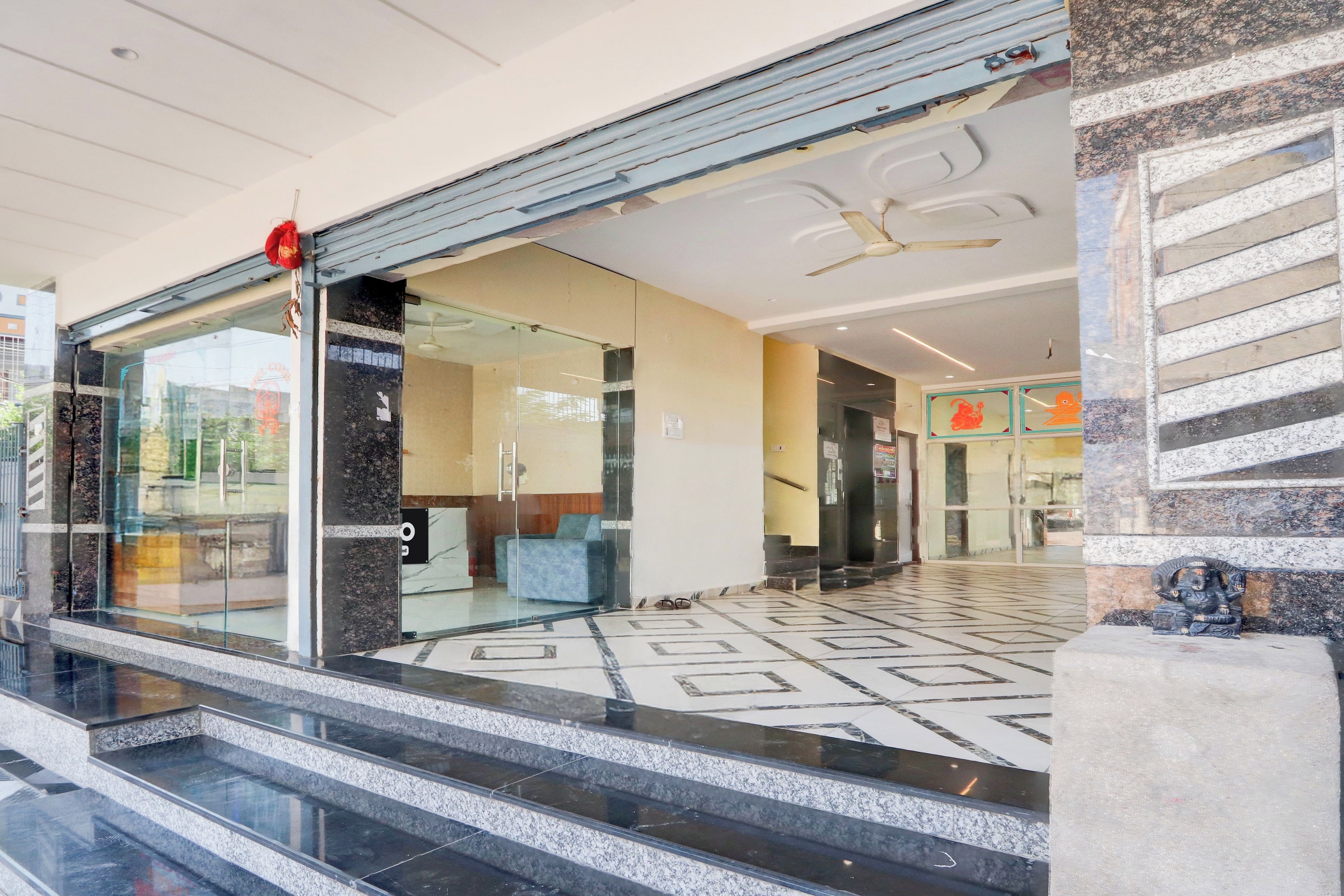 Un'hall dell'hotel con una reception, una scala e un pannello decorativo.