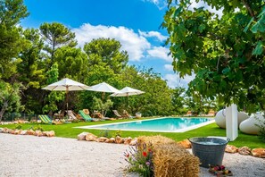 A pool area with lounge chairs and umbrellas, surrounded by trees and a clear sky. - Trulli San Domenico by Perle di Puglia (Martina Franca)