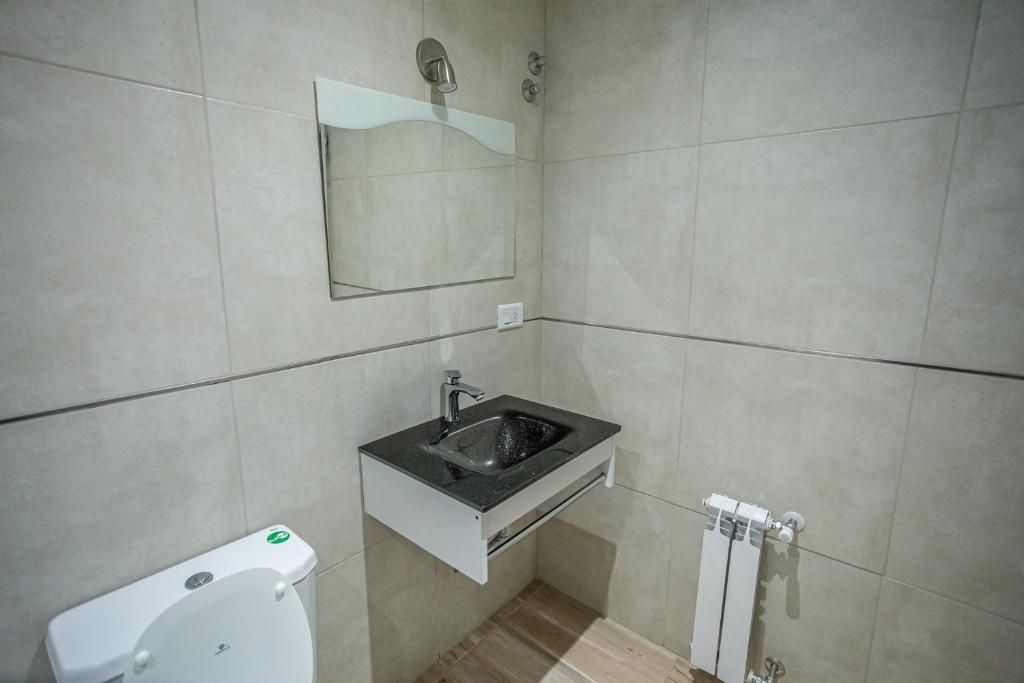Une salle de bain avec des toilettes, un lavabo et un miroir.