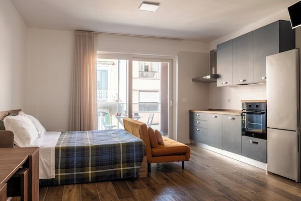 A modern bedroom with a bed, a chair, and a view of the balcony. - Marietta's House by BarbarHouse (Bari)