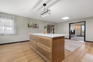 A spacious room with a wooden cabinet, a white countertop, and a hanging light fixture. - 6 Bedroom/3 Bathrooms, 6 Acres Country House (Aberdeen)