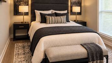 A bedroom with a bed, two bedside tables, a ceiling fan, and artwork on the walls.