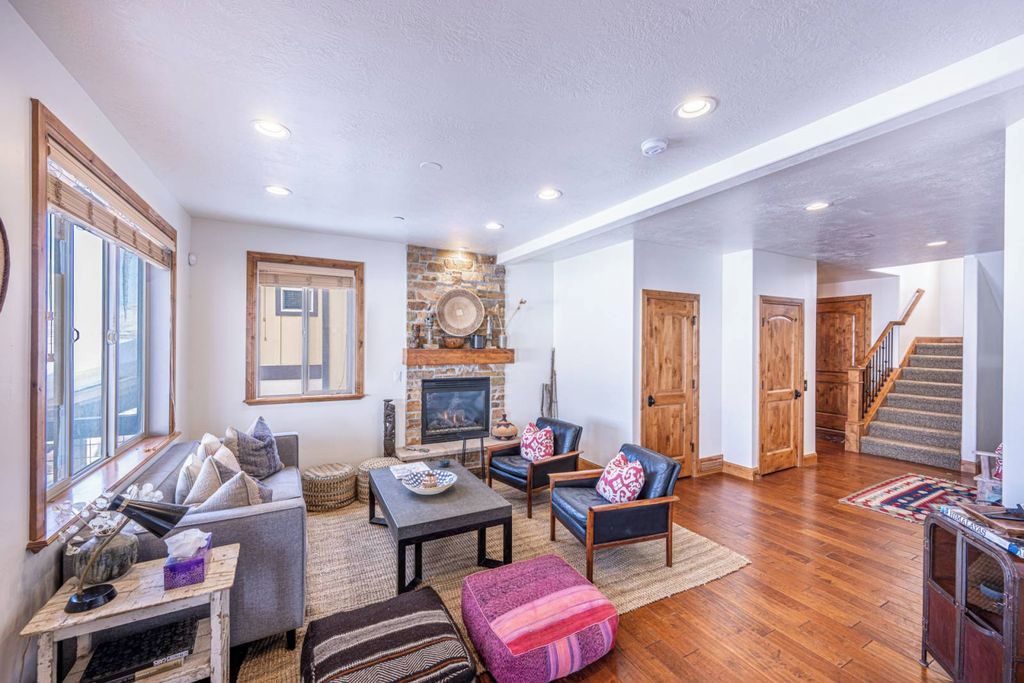 A spacious living room with a fireplace, a staircase, and a cozy seating area.