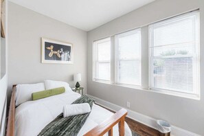 A bedroom with a bed, a nightstand, a lamp, and a framed picture on the wall. - Artsy Chicago Stay with Patio, Parking & Sleeps 7 (Chicago)