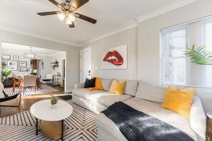 A living room with a sofa, a coffee table, and a ceiling fan. - Artsy Chicago Stay with Patio, Parking & Sleeps 7 (Chicago)