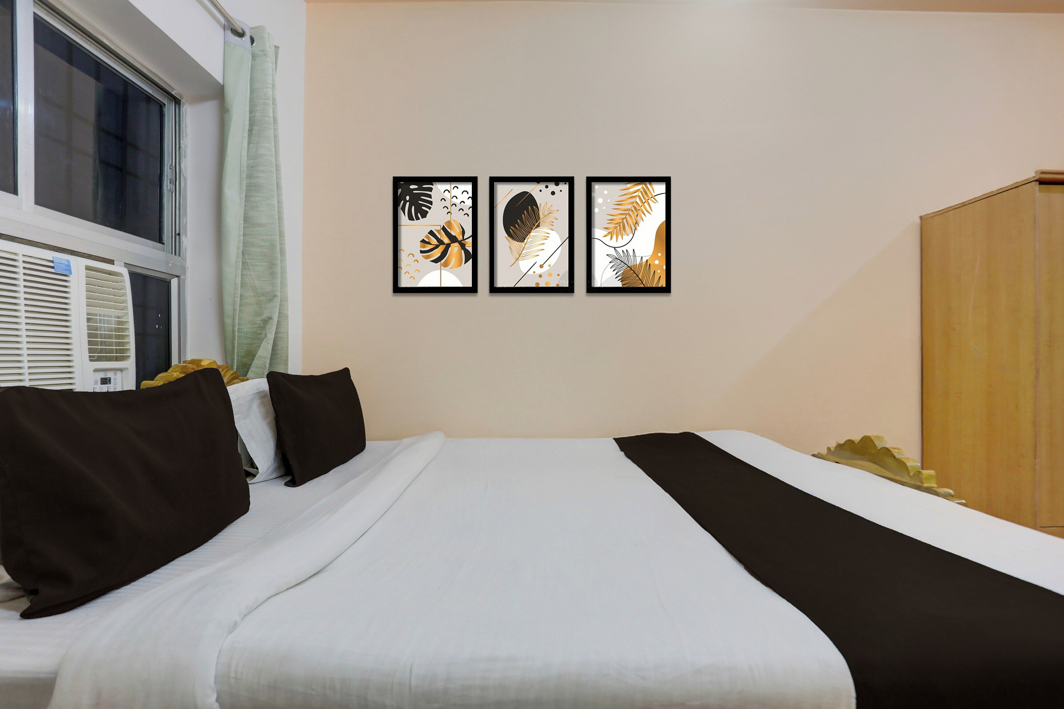 Una habitación de hotel con una cama, una ventana y tres cuadros en la pared.