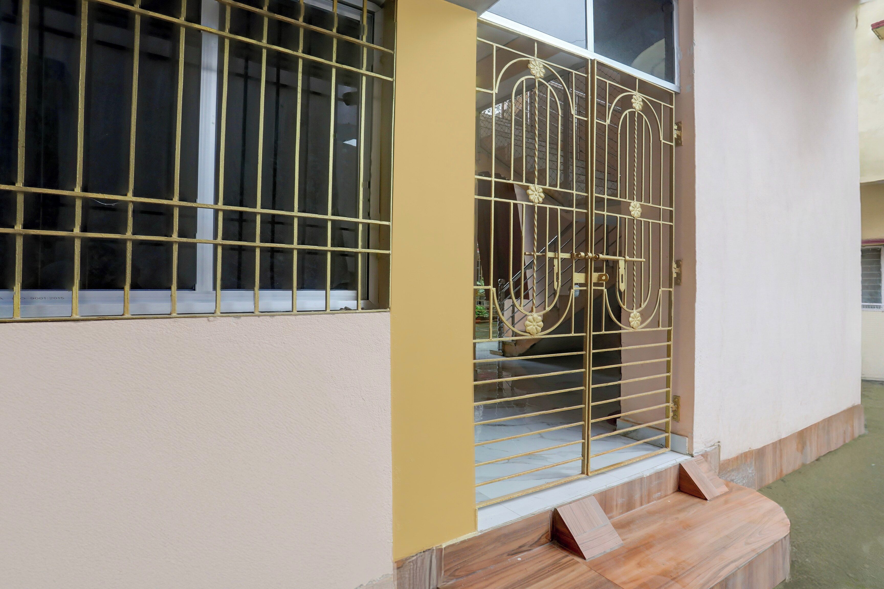 Un edificio con rejas en las ventanas y una entrada con portón.