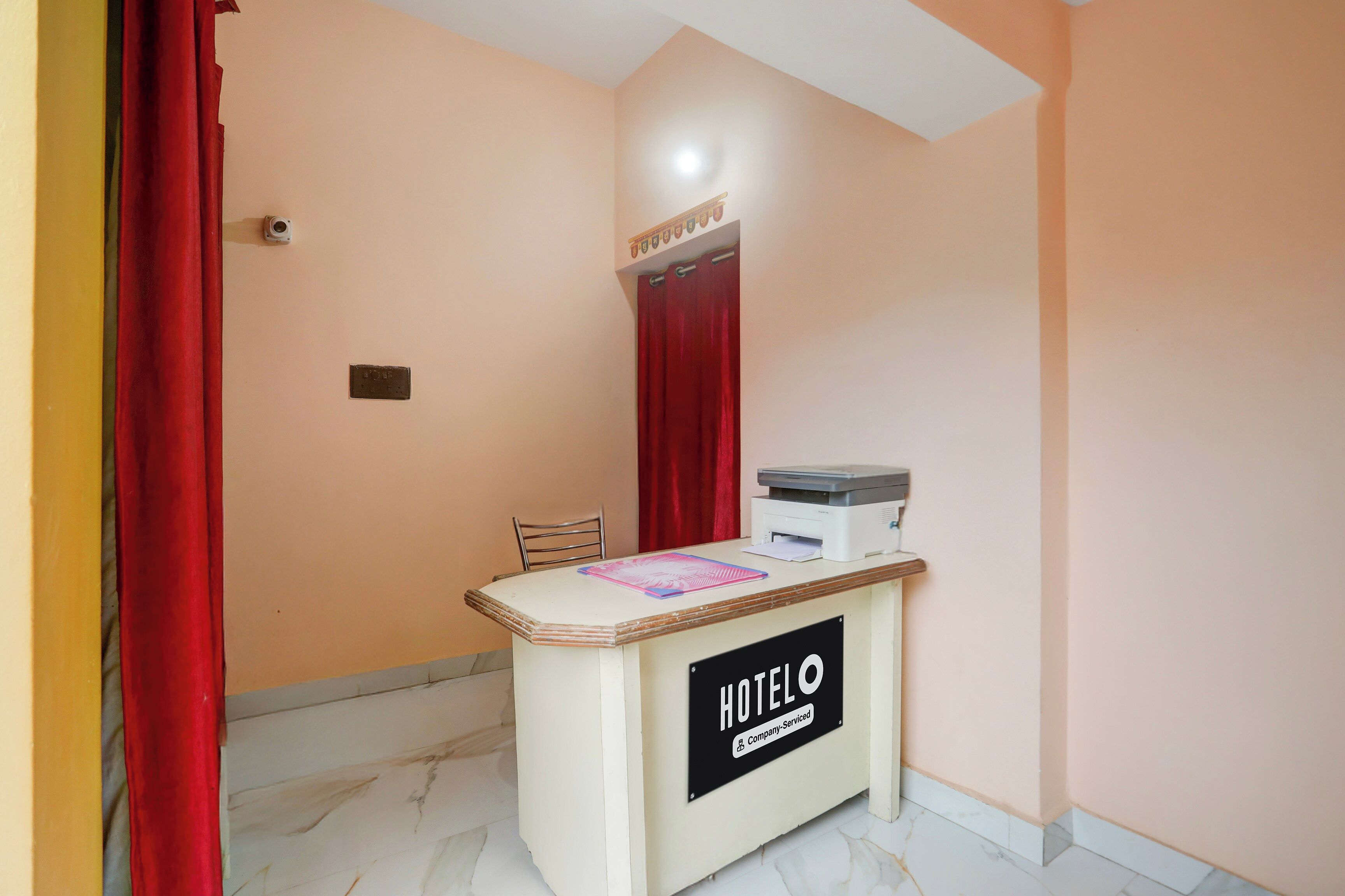 Un mostrador de recepción con un letrero que indica 'HOTEL' y 'Servicio de empresa'.
