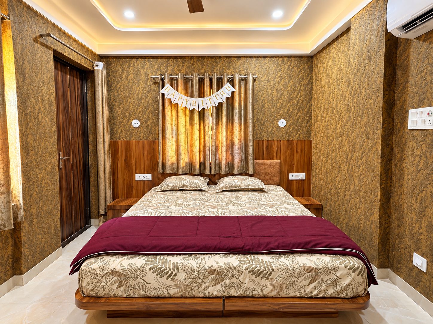 Un dormitorio con cama, cortinas, cabecera y aire acondicionado de pared.