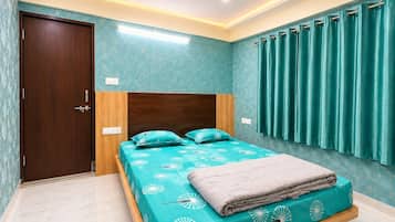 Un dormitorio con una cama, un ventilador de techo y una ventana con cortinas.