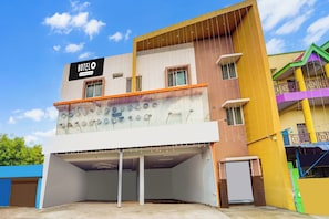 A multi-story hotel with a sign indicating it is company-serviced. - Super Hotel O Aarapalayam (Madurai)