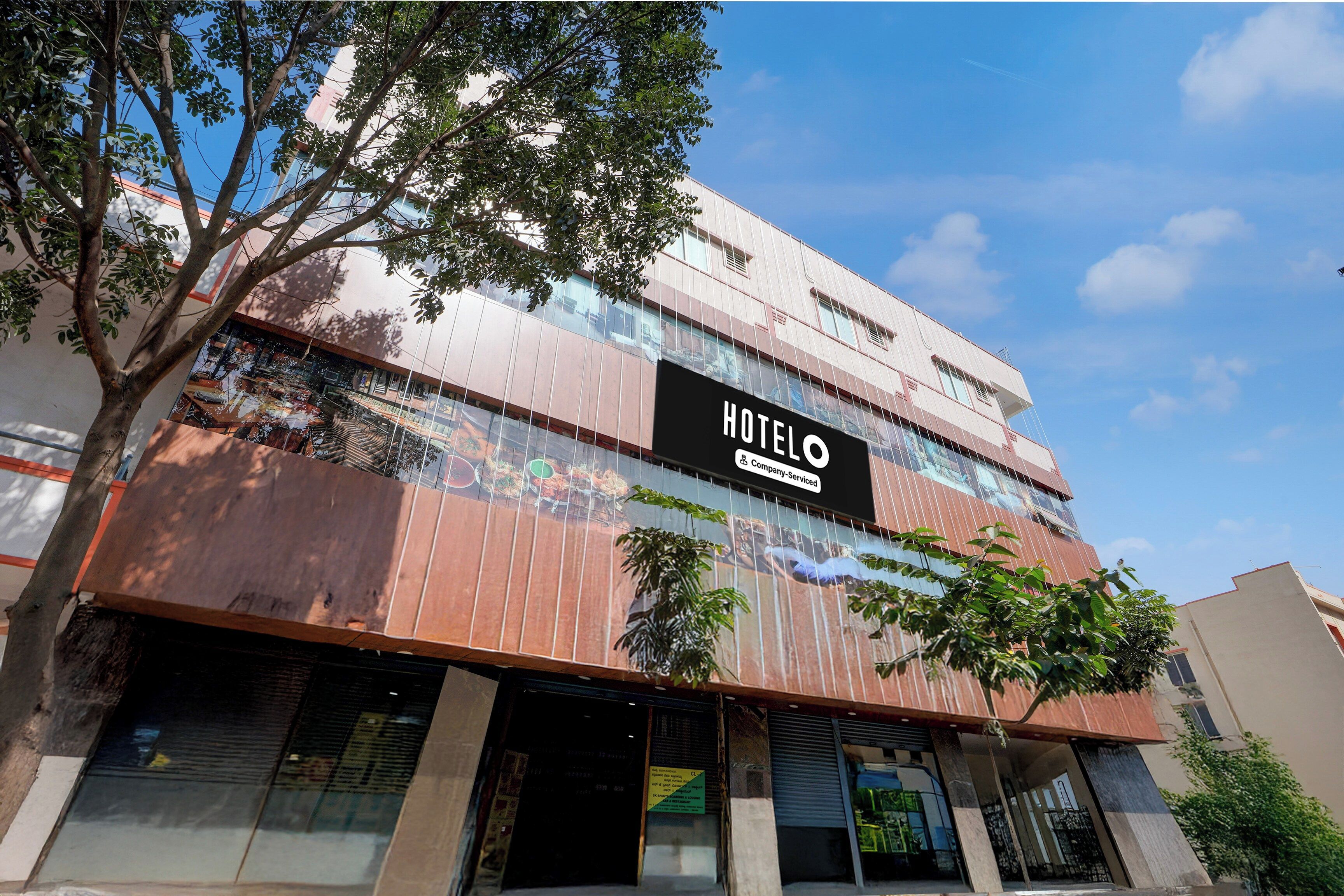 A hotel building with a sign reading 'HOTEL' and a company-serviced logo.