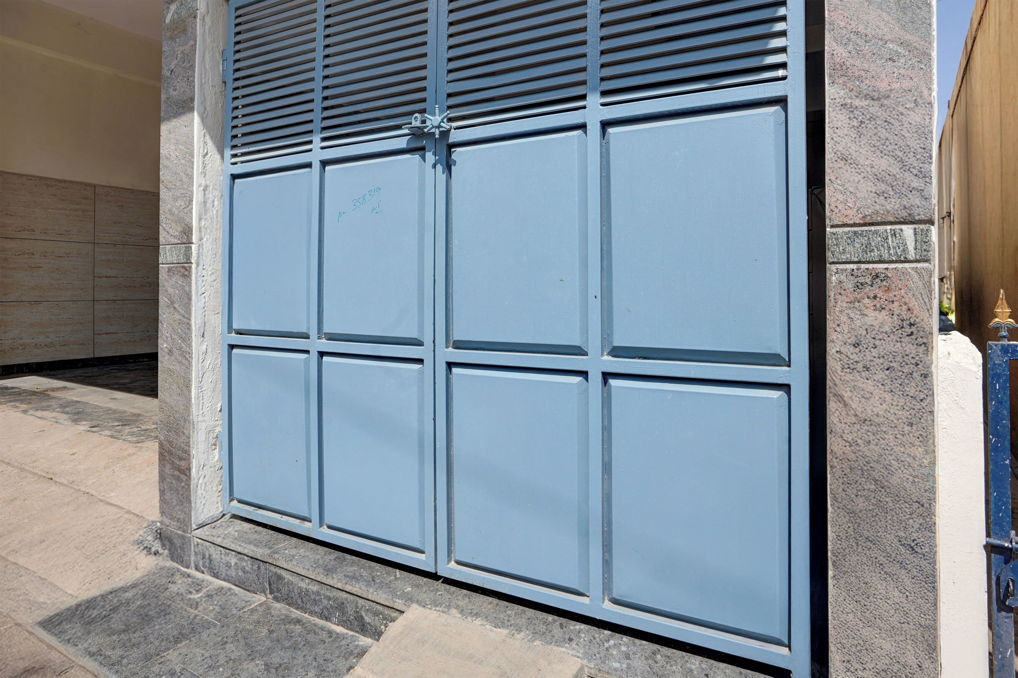 A large, blue garage door with a security lock and a keyhole.