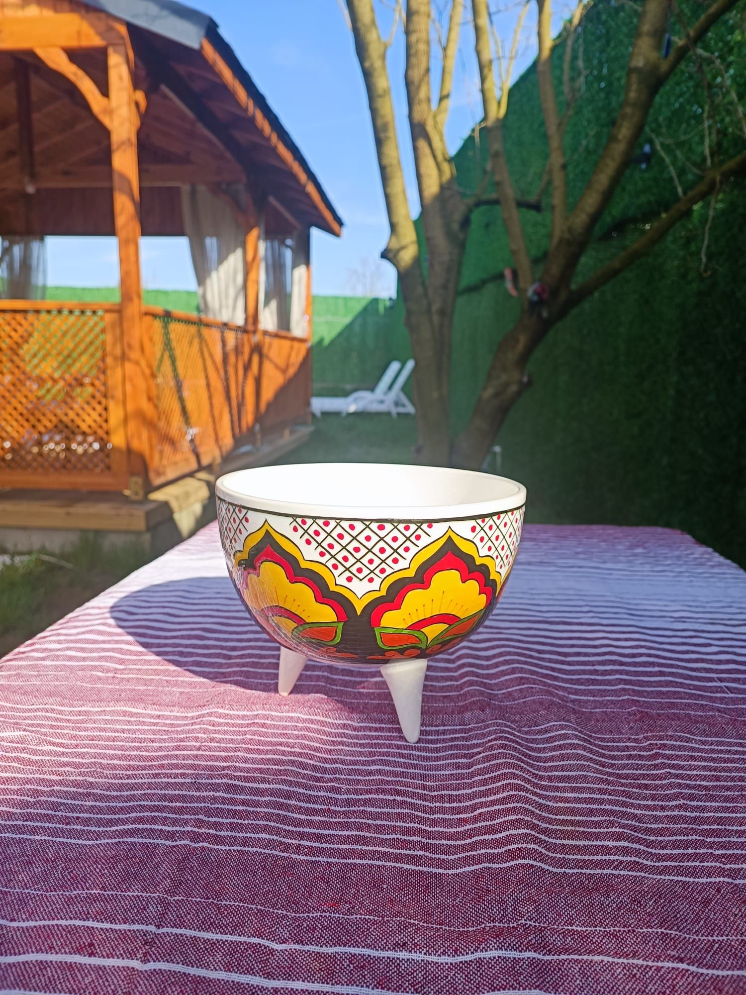 A white bowl with colorful patterns on a textured surface.