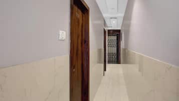 Un pasillo con una puerta de madera marcada '101' y una reja metálica al final.