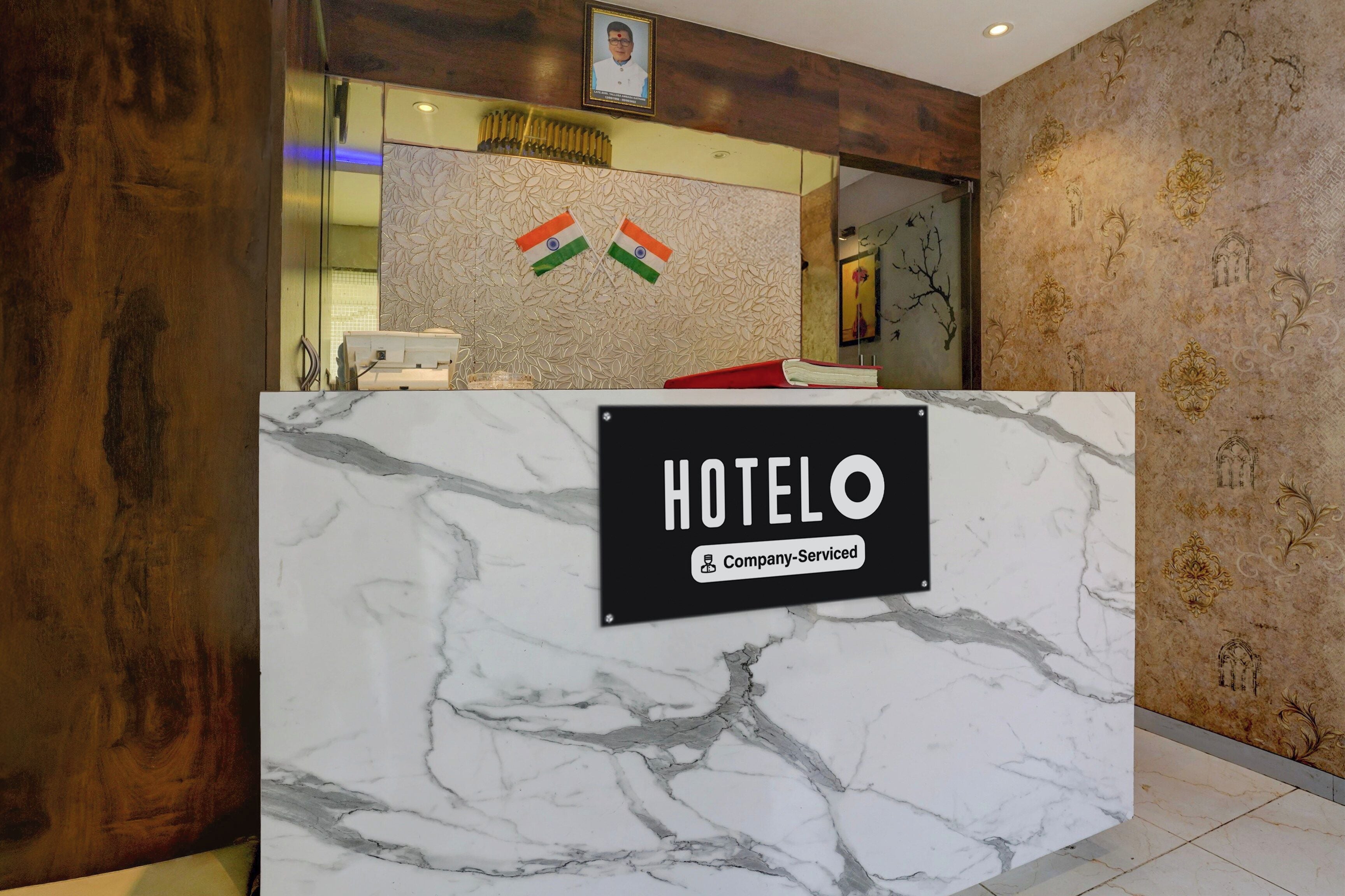 Mostrador de recepción de hotel con encimera de mármol y un letrero que indica servicio corporativo.