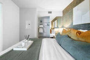 A modern hotel room with a bed, a bedside table with a tray, a lamp, and a wardrobe. - Fort York 1BR, Balcony Near the Waterfront (Toronto)