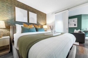 A modern hotel room with a large bed, a nightstand, a desk, and a chair. - Fort York 1BR, Balcony Near the Waterfront (Toronto)