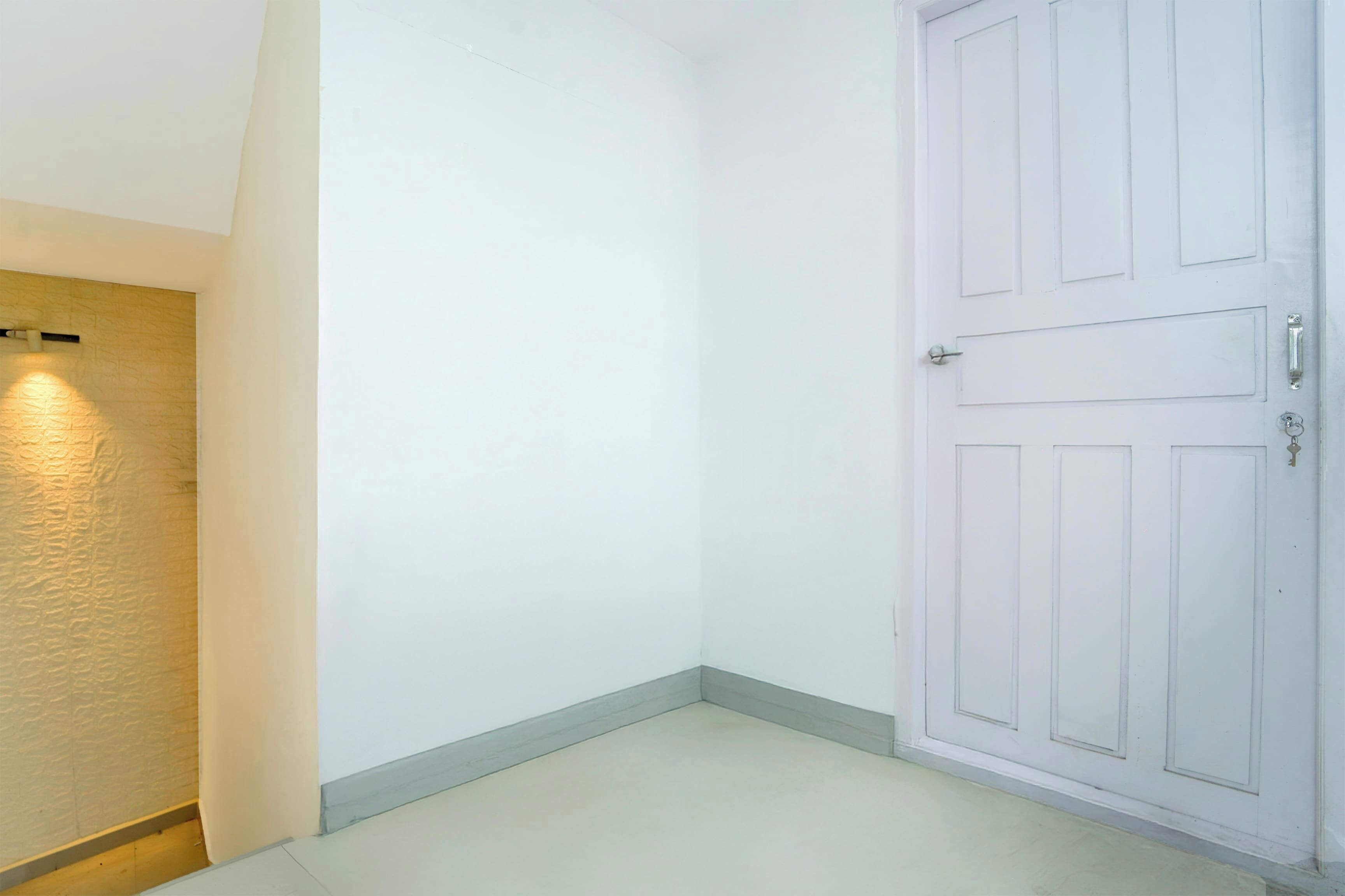 Un pasillo con una puerta blanca y una pared de superficie texturizada.