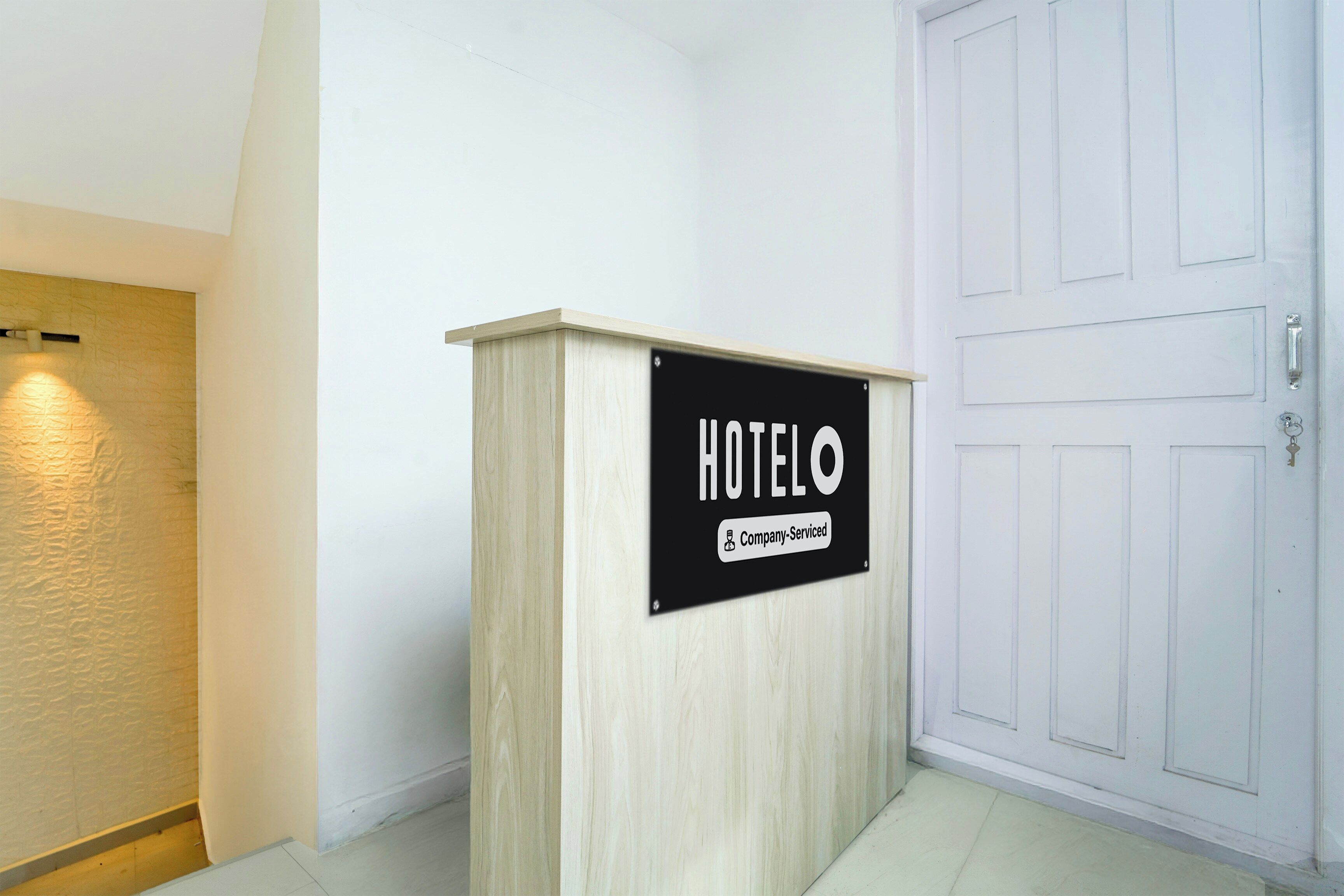 Mostrador de recepción de hotel con un aviso que indica servicio de empresa.
