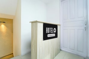 Taulell de recepció d'hotel amb un senyal que indica que ofereix servei empresarial.
