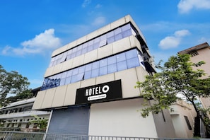 A modern hotel building with a prominent 'HOTEL O' sign, large windows, and a metal gate. - Hotel O Chakkaraparambu Vyttila (Kanayannur)