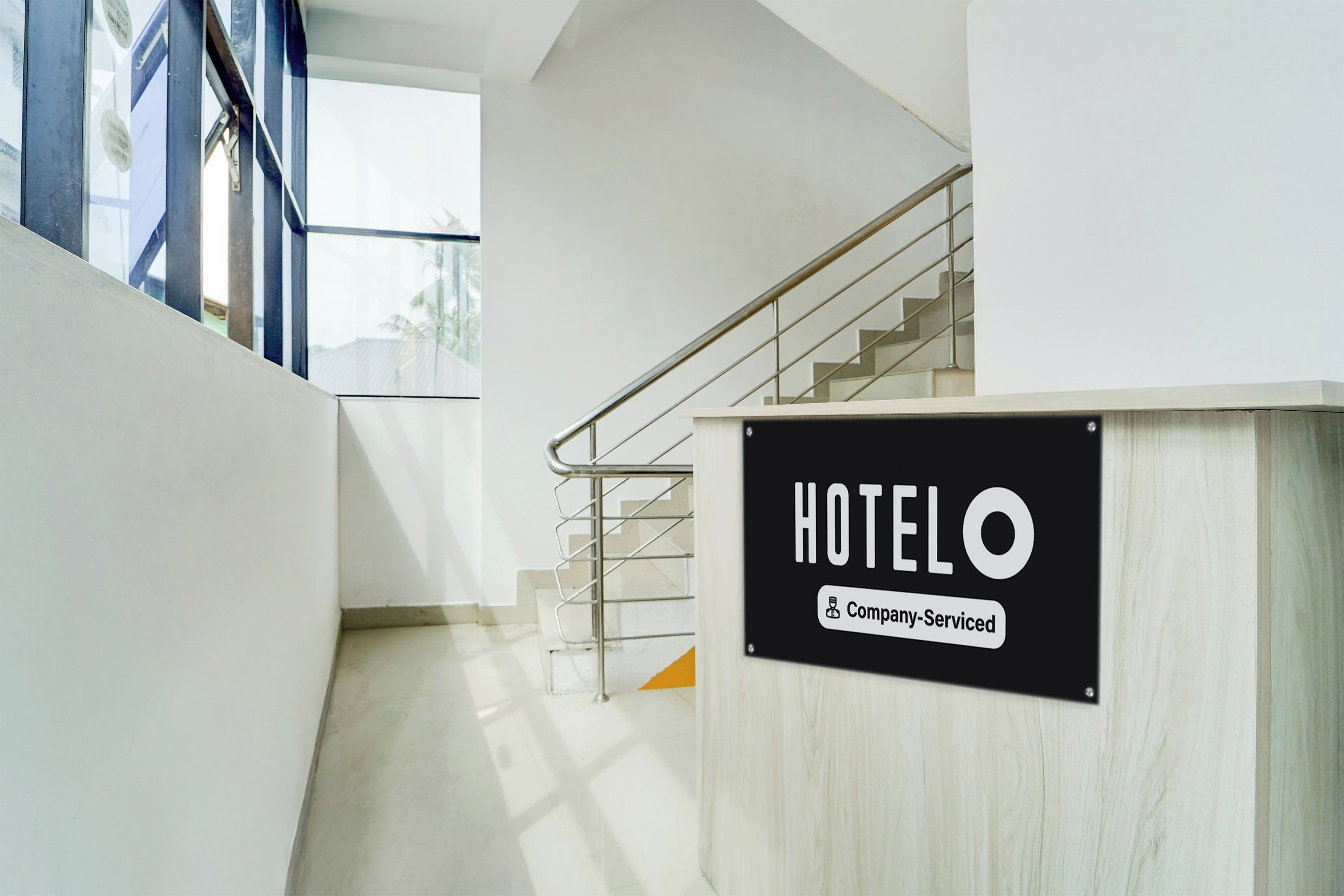 Zona de recepción de hotel con un cartel que indica servicio para empresas.