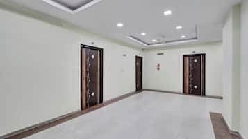 Un couloir avec quatre portes, chacune ornée d’un motif décoratif, et un plafond doté d’un éclairage encastré.