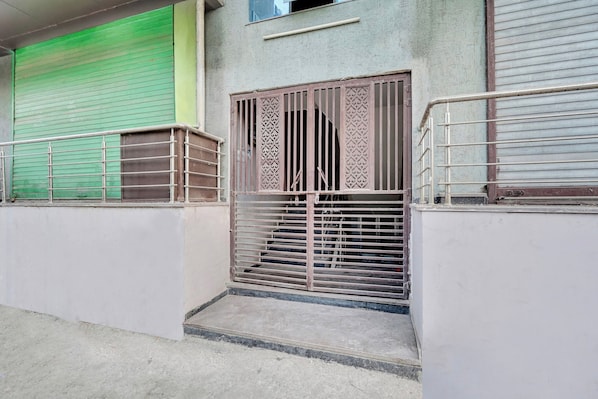 A gated entrance with a metal gate and a staircase leading to a building.