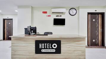 A hotel reception desk with a sign reading 'HOTELO & Company-Serviced'.
