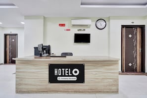 A hotel reception desk with a sign reading 'HOTELO & Company-Serviced'.