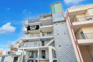 Un hotel de varios pisos con balcones y un cartel que indica que es administrado por OYO.