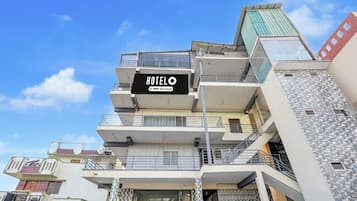 Un hôtel à plusieurs étages, avec une enseigne indiquant qu’il est géré par OYO.