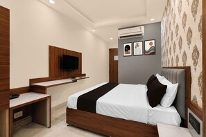 Un dormitorio moderno con cama, mesita de noche y televisor montado.