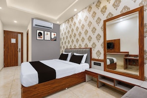 A modern bedroom with a large bed, bedside tables, a mirror, and an air conditioning unit. - Townhouse ISBT Bus Terminal Bhopal (Bhopal)