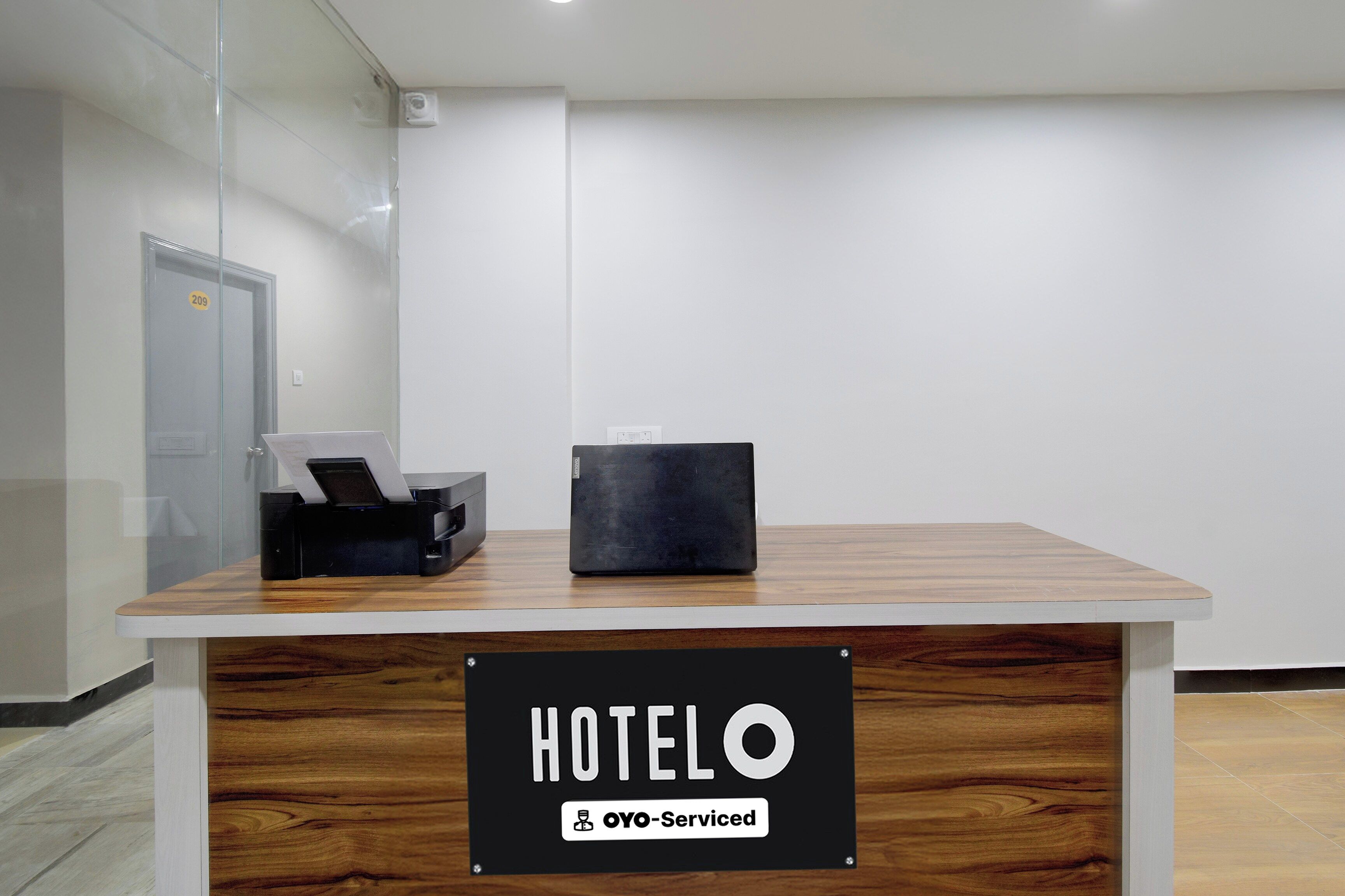 Mostrador de recepción de hotel con un letrero que indica servicio OYO.