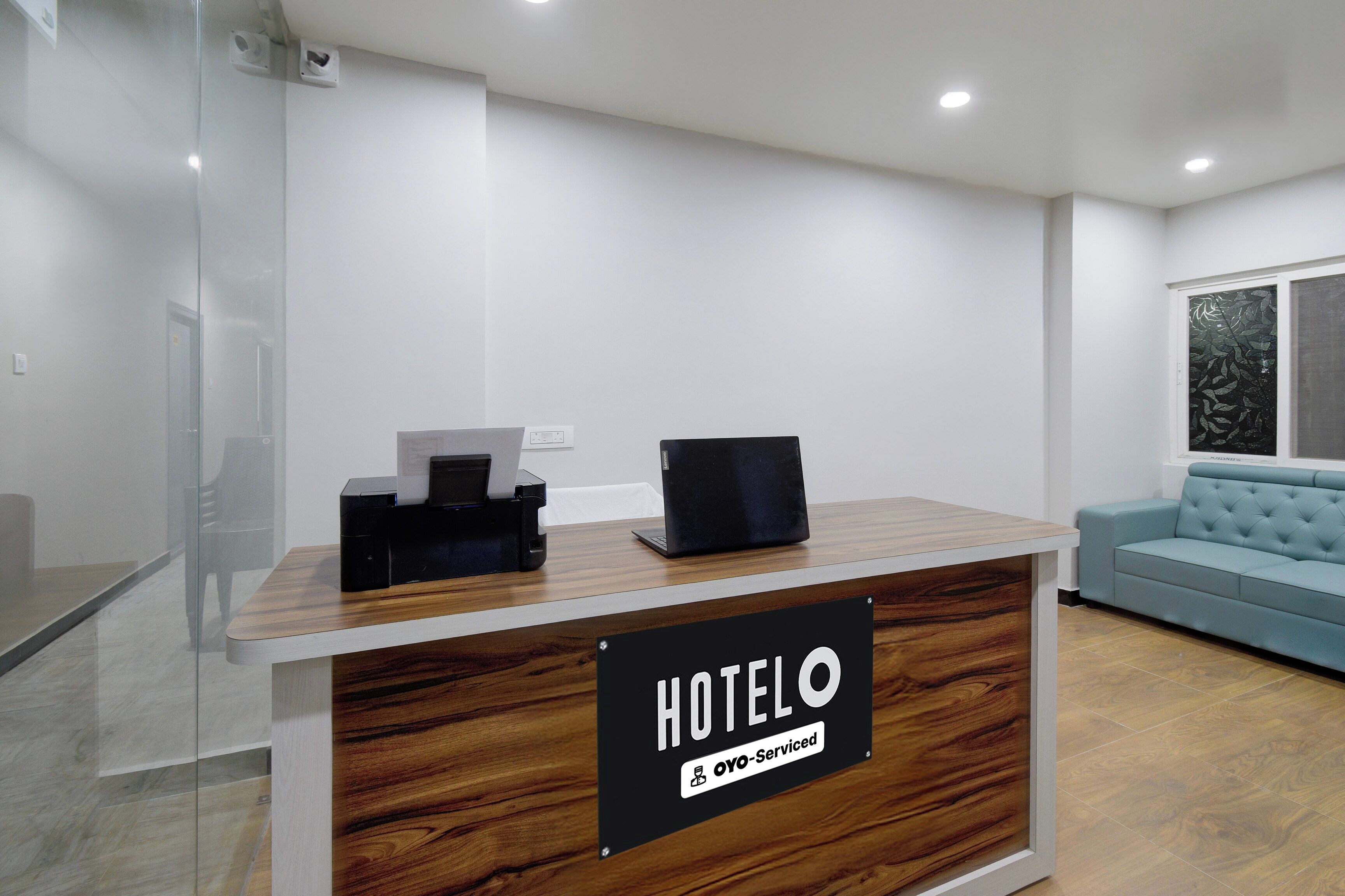 Una recepción de hotel con un cartel que indica que es administrado por OYO.