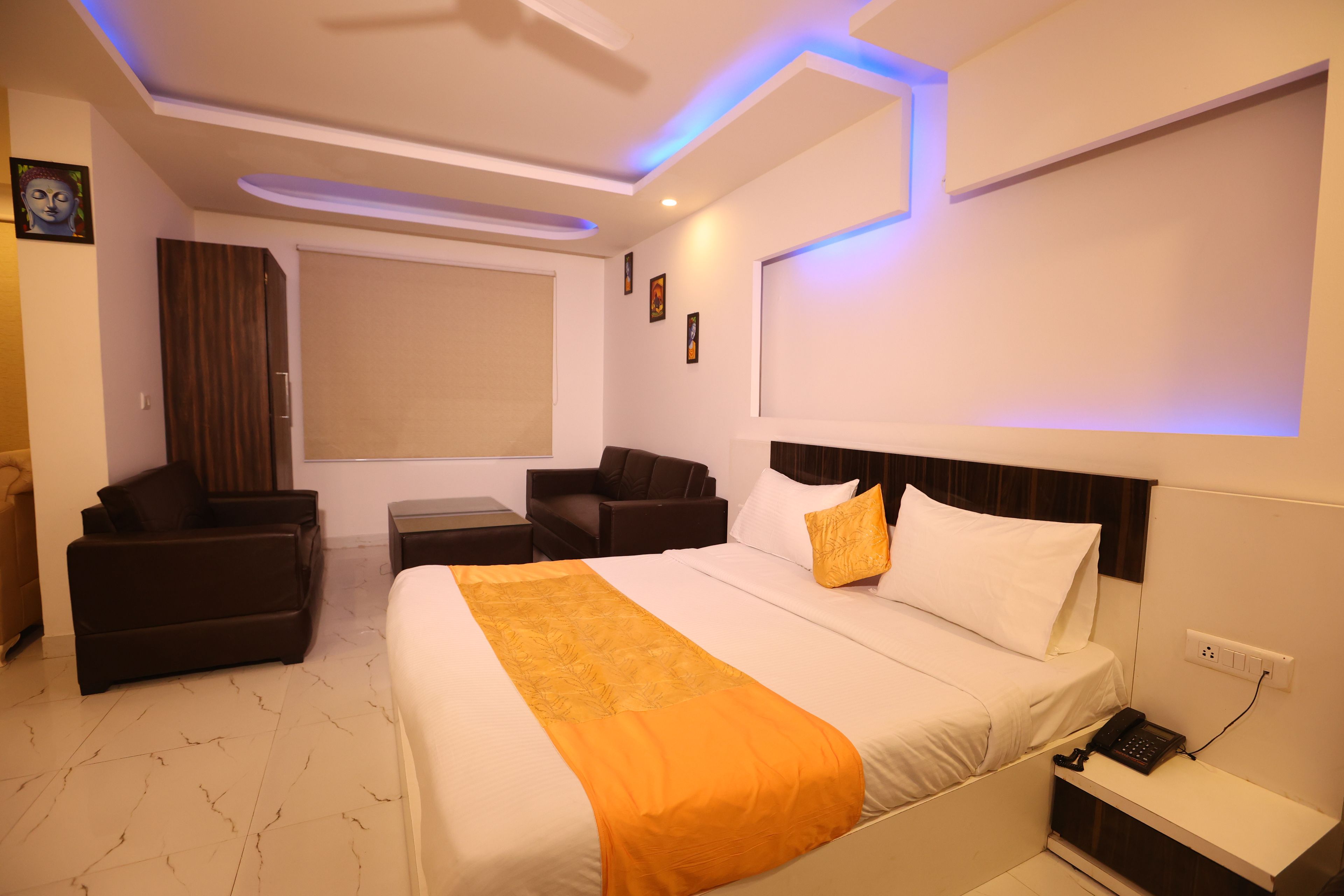 Una habitación de hotel con cama, escritorio, silla, sofá y ventana.