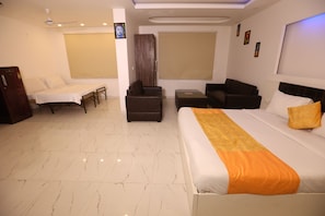 Habitación de hotel con cama, sofá, escritorio, silla y armario.