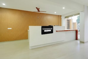 Una mesa de recepción con un cartel que indica que el servicio es proporcionado por OYO.