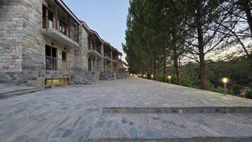Un edificio de piedra con varios balcones y un patio empedrado.