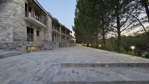 Un edificio de piedra con varios balcones y un patio empedrado.