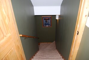 A narrow stairway with a wooden handrail, carpeted steps, and a small framed picture on the wall. - Sapphire Outpost, A Quiet Hilltop Cabin with Stunning Mountain Views (Stevensville)