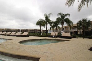 A pool area with lounge chairs and palm trees. - 3212 Magic Village 8 Guests Lakefront 8 min Disney (Kissimmee)