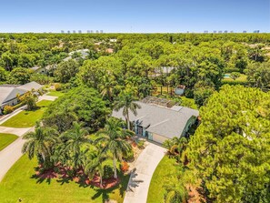 A residential area with a large house surrounded by lush greenery and a well-maintained lawn. - Pineapple Paradise Retreat Private Pool and Spa (Bonita Springs)