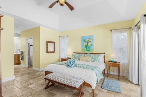 A bedroom with a bed, bedside tables, a ceiling fan, and a window with curtains. - Pineapple Paradise Retreat Private Pool and Spa (Bonita Springs)