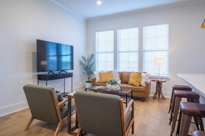 A modern living room with a sofa, chairs, a coffee table, a TV, and a plant. - The Wheels Down, Runway Views by VelvetDitchVillas (Oxford)