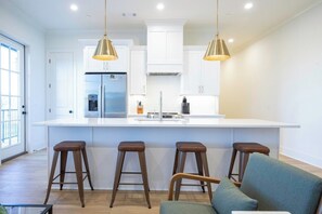 A modern kitchen with a central island, bar stools, and pendant lighting. - The Wheels Down, Runway Views by VelvetDitchVillas (Oxford)