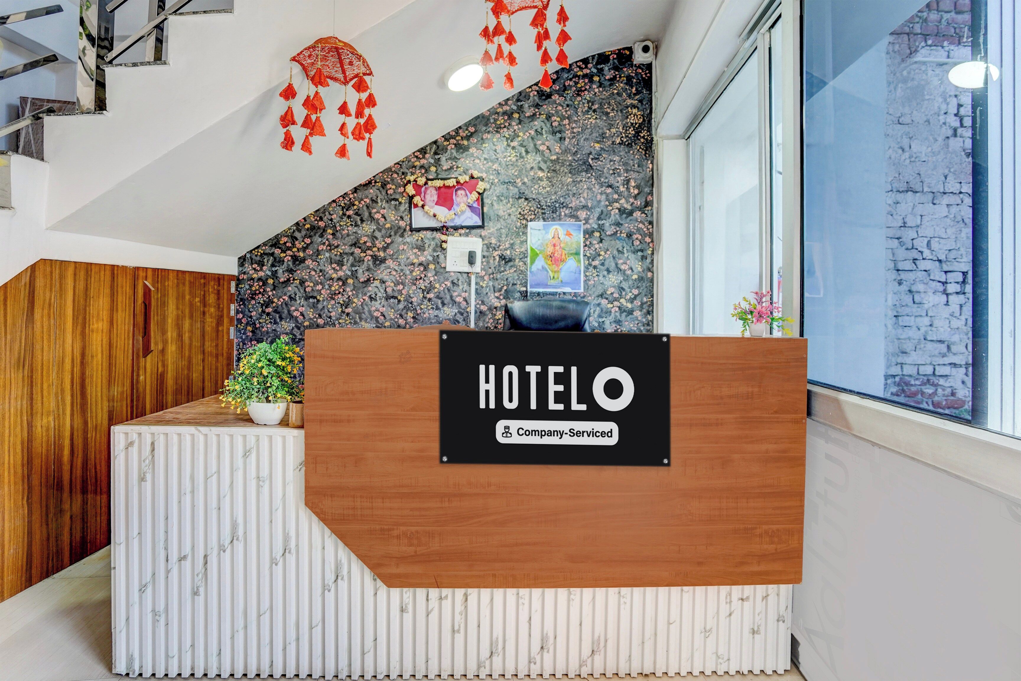 Un taulell de recepció d'hotel amb acabat de fusta i disseny semblant a marbre.